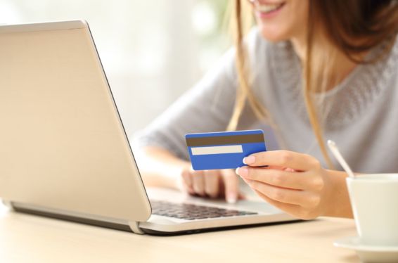 Woman at a computer holding a credit card